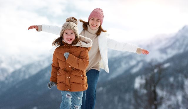 Une maman et sa fille de 10 ans se baladent et jouent dans la neige